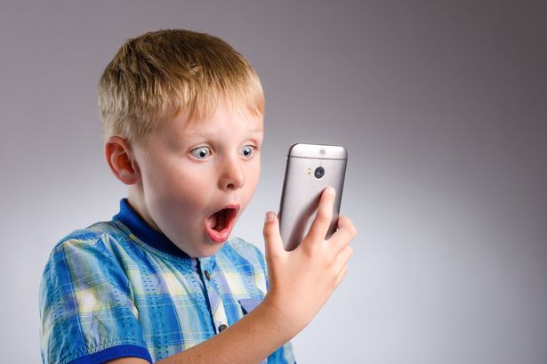 child shocked looking at phone screen
